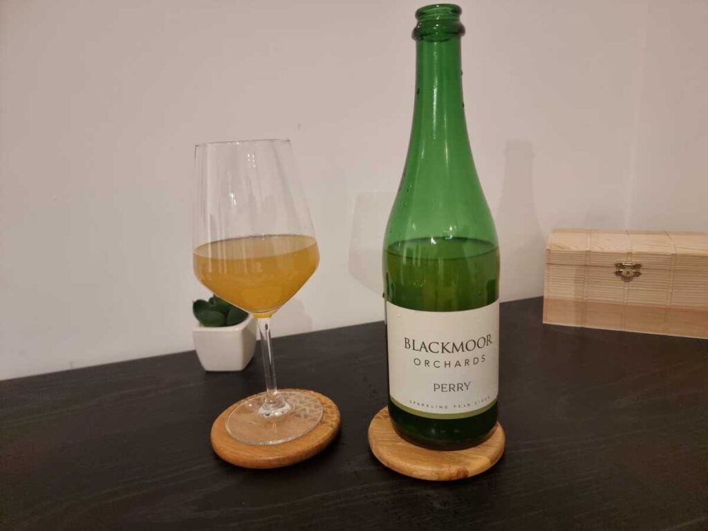 Blackmoor Orchards Perry 2022 - cider in glass with bottle_featured image